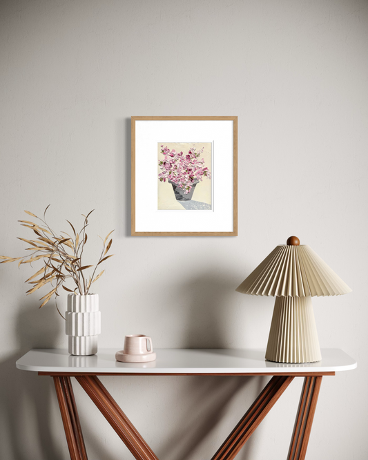 Pink bloom floral painting displayed above a wooden console in a warm neutral interior